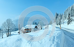 Morning winter misty rural alpine road and house