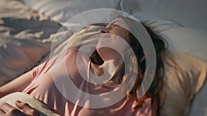 Morning woman lying asleep in sunlight closeup. Peaceful girl waking up in bed.