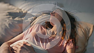 Morning woman lying asleep in sunlight closeup. Peaceful girl waking up in bed.