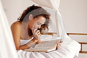 Morning Woman Reading Book. Smiling Girl Read Book While Laying on Bed