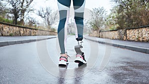Morning workout. Cropped photo of of disabled athlete woman in sportwear with prosthetic leg standing outdoor photo