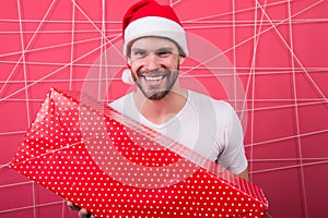 The morning before Xmas. man in santa hat hold christmas present. happy man enjoy the holiday. delivery christmas gifts