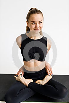 Morning yoga session, a woman sits in a lotus position on a mat