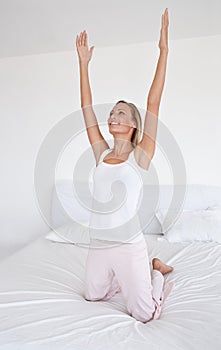 Morning, yoga and woman stretching on the bed with gratitude for happiness, health or wellness in home. Wake up