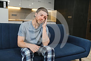 Morning of young man suffering from hangover at home