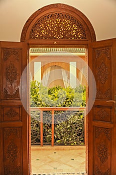 Moroccan balcony entrance with carved wooden doors and fanlight