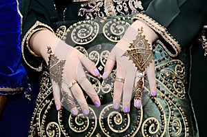 Moroccan bride puts henna on her hands.