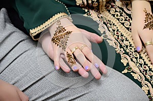 Moroccan bride puts henna on her hands.