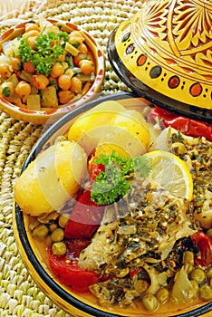 Marocchino di pesce marinato in salsa Chermoula assaporare, bollito con patate novelle, piselli e pomodori.