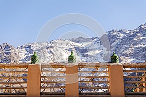 Moroccan green lantern on the top of the fence with Toubkal mountain range in Morocco