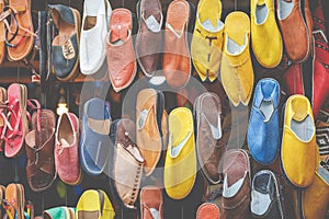 Moroccan leather goods bags and slippers at outdoor market in Ma