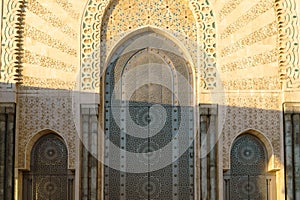 Moroccan mosaic and patterns , view of Hassan II Mosque big gate, Detail of Hassan II Mosque at sunset in Casablanca, Morocco