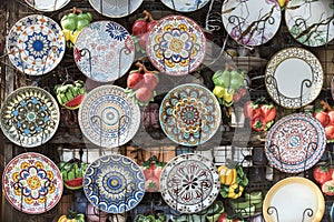Moroccan plates hanging on an outside display rack with fruit wall decors, for sale at a flea market