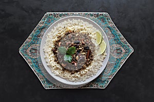 Moroccan spiced mince with couscous on a black.