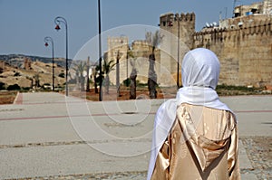 Moroccan woman in golden djellaba and white hijab