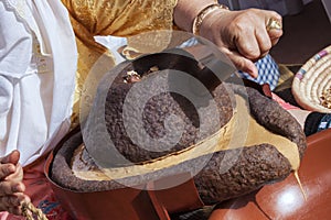 Moroccan woman grinding argan kernels traditionally with a mills