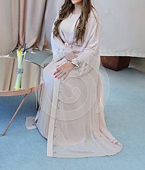 Moroccan woman wears a white caftan. Traditional Moroccan dress photo