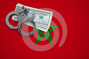 Morocco flag with handcuffs and a bundle of dollars. The concept of breaking the law and thieves crimes