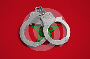Morocco flag and police handcuffs. The concept of observance of the law in the country and protection from crime