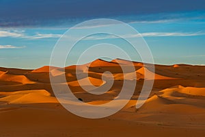 Morocco. Merzouga. Sand dunes of Sahara desert under a blue sky at dusk