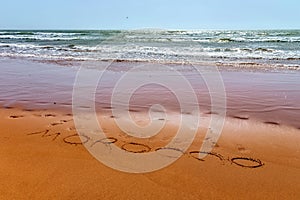 Morocco word is written on the sandy beach of the Atlantic ocean coast in Morocco