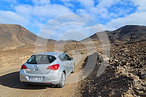 MORRO JABLE TO COFETE BEACH ROAD, FUERTEVENTURA - FEB 8, 2014: hire car on unpaved road to Cofete beach. This area is secluded