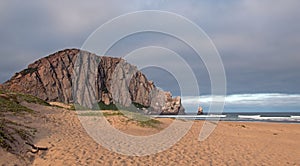 Morro Rock at sunrise under cumulus clouds at Morro Bay State Park camping spot on the Central California Coast USA