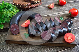 Morsilla - blood sausage. Pieces of Spanish black pudding on a wooden cutting board. Easter menu