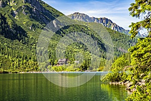 Morskie Oko mountain lake, surrounding forest, Miedziane and Opalony Wierch peaks with Schronisko przy Morskim Oku shelter house photo