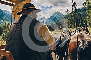 Morskie Oko, Poland, 05/07/2019 Close up photo of old cartman in hat that drives horses, riding a mountain road