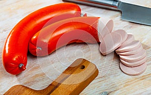 Mortadela sausage cut in slices on a wooden surface photo