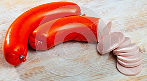 Mortadela sausage cut in slices on a wooden surface photo