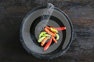 Mortar contains colorful chilies, ready to be pulverized and processed