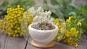 mortar with dried and fresh medicinal herbs plants on wooden table