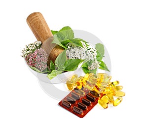 Mortar with fresh herbs and pills on white background