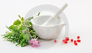 Mortar, herbs and pills on white background