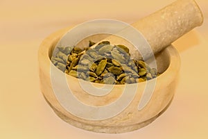 mortar and pestle with green cardamon elachi spices photo