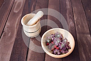 The mortar and pestle with herbs and a Cup of dried berries