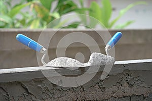 Mortar pile on trowels put on a brick block wall in construction site