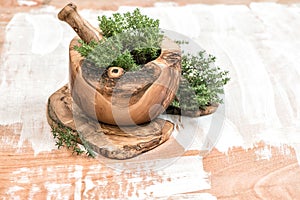 Mortar with thyme sprigs. Olive wood kithchen tools. Herbs and s