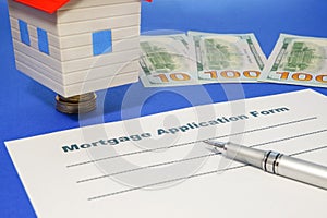 Mortgage application form with a pen and house.