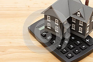 Mortgage calculator with a house on a wood desk