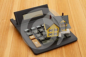 Mortgage calculator with a house on a wood desk