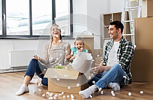 Happy family playing with foam peanuts at new home