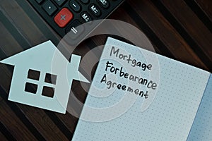 Mortgage Forbearance Agreement write on a book isolated on Wooden Table