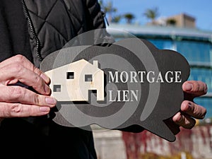 Mortgage lien on the poster and model of house. photo
