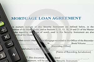 Mortgage loan agreement sign contract concept, pen with calculator on mortgage form or contract, long term debt or real estate in