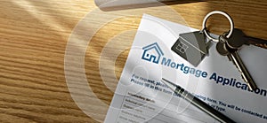 Mortgage loan application form and new home keys on the bank office table. copy space