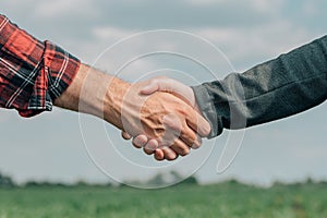 Mortgage loan officer and farmer shaking hands upon reaching an agreement