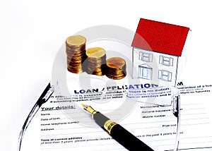 Mortgage loans concept with Fountain pen and eyeglasses and paper house and coins stack on Laon Application form